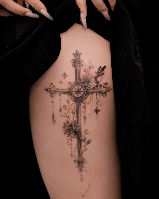 An ornate cross with flowers tattooed on the back