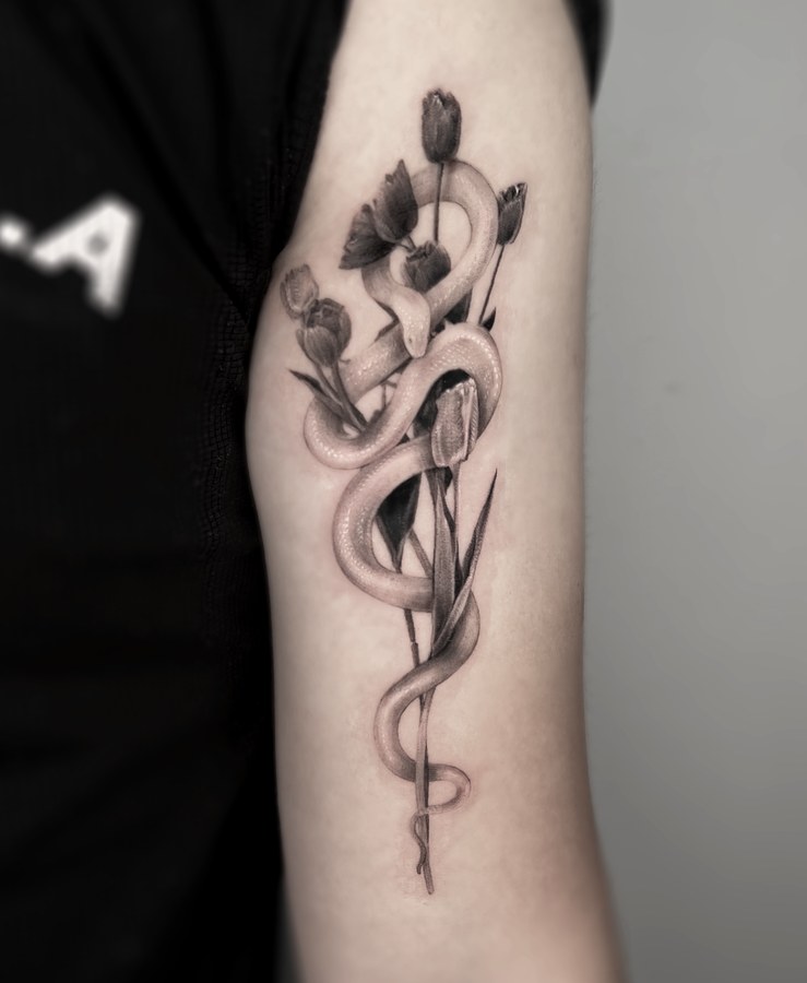 A snake and tulips tattooed on the arm