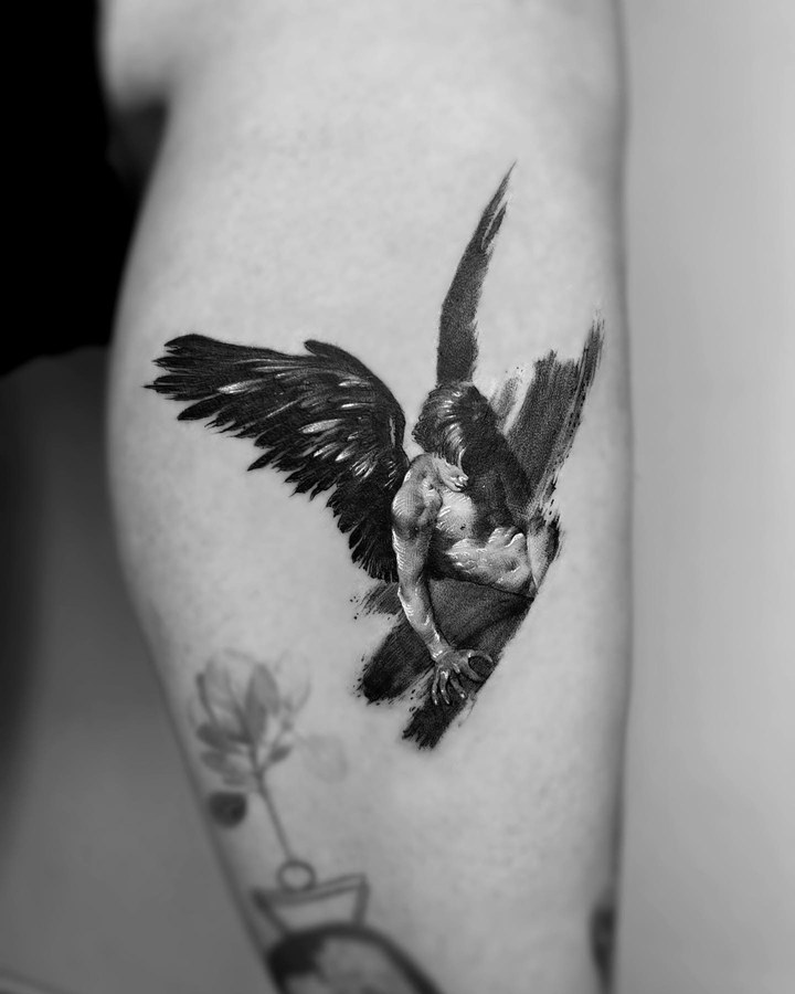 An angel with folded wings tattooed on the calf