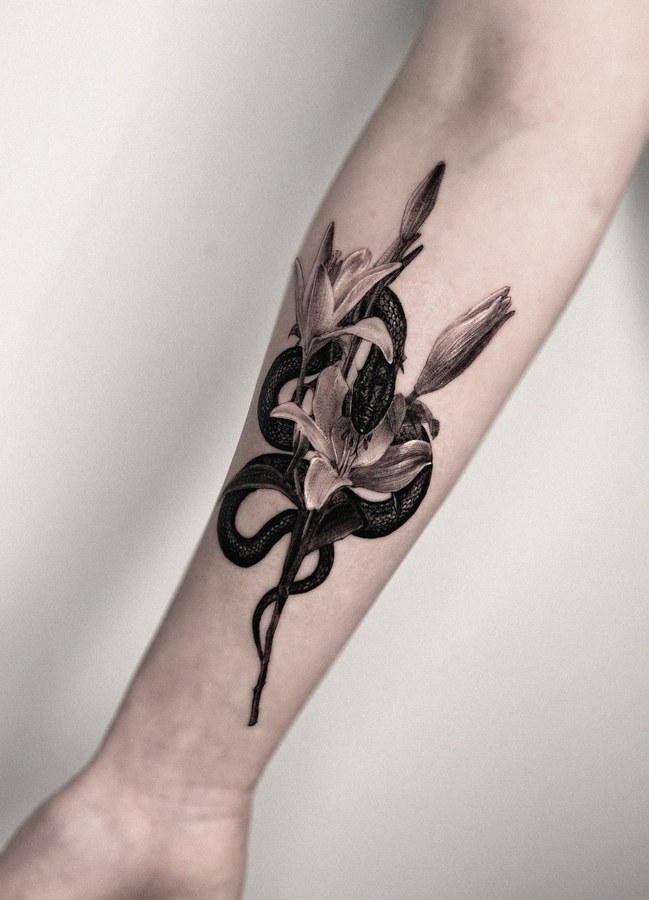 A snake and flowers tattooed on the arm