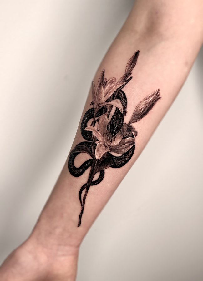 A snake and flowers tattooed on the arm