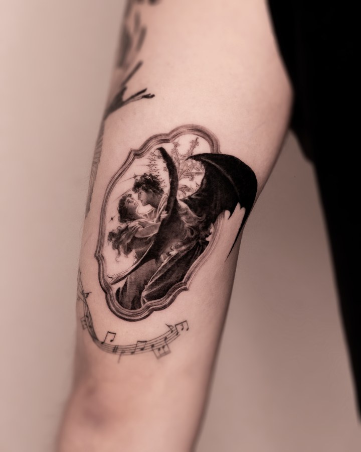 A skull with flowers and lettering, tattooed on the arm