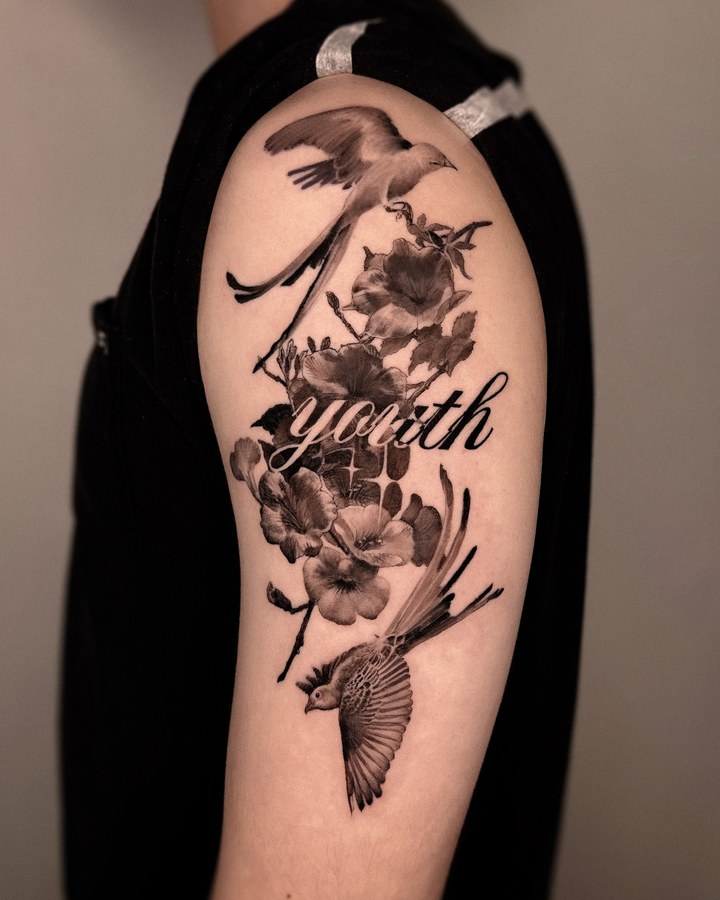 Flowers with lettering tattooed on the arm