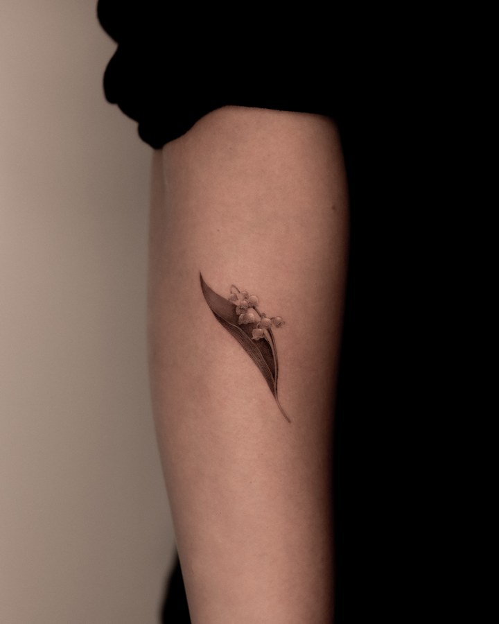 Small lily of the valley in fine line, tattooed on the inner arm