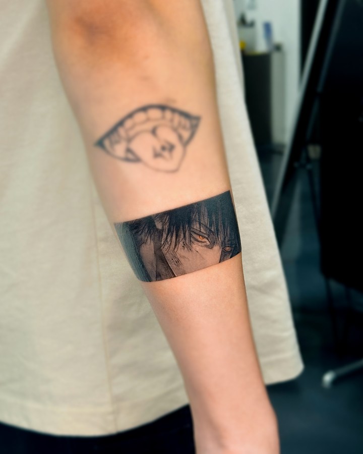 An anime-style eye tattooed on the arm