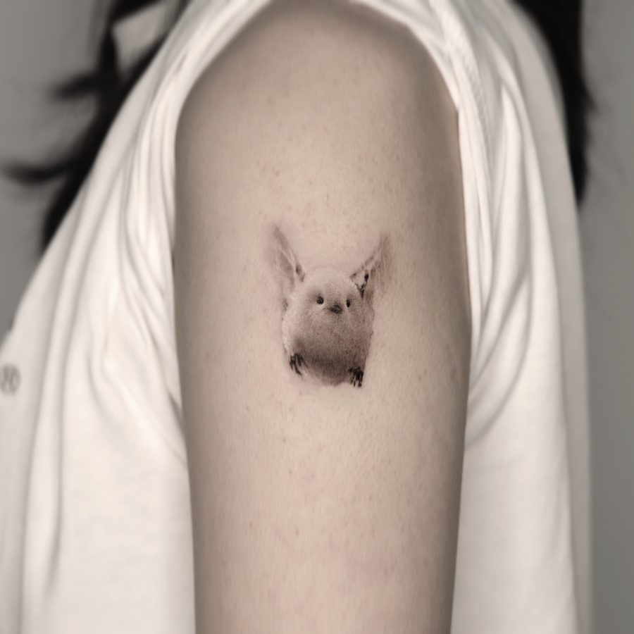 A small bird, a mini tattoo on the arm