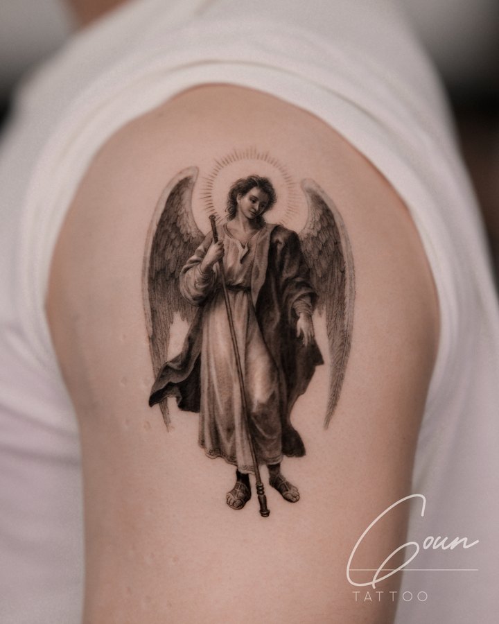 An archangel in black and grey, tattooed on the outer arm