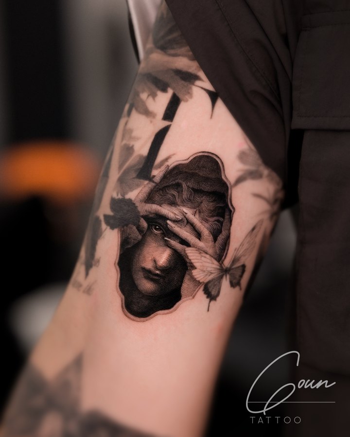 A portrait of a woman with a butterfly, tattooed on the arm