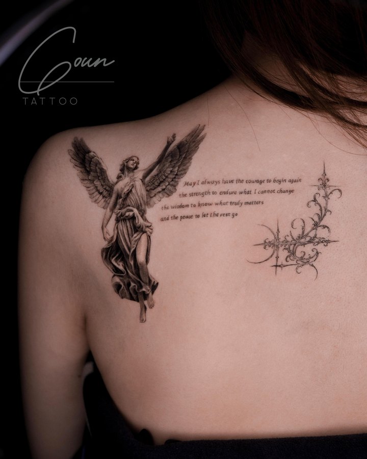 An angel statue with lettering, tattooed on the back