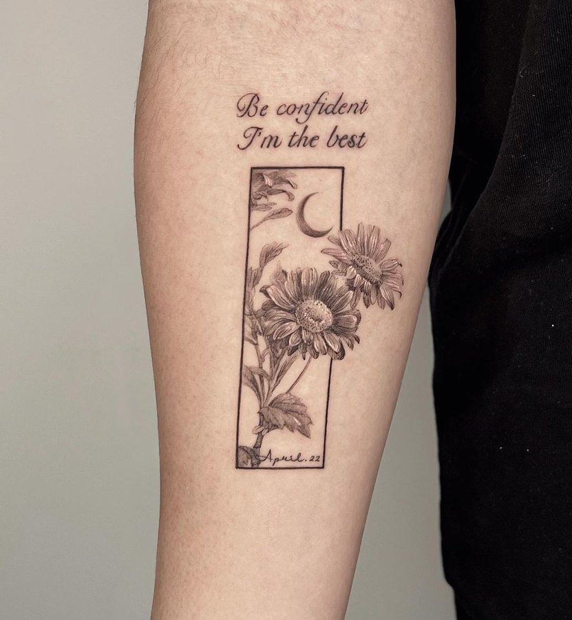 A chrysanthemum frame with lettering, tattooed on the arm