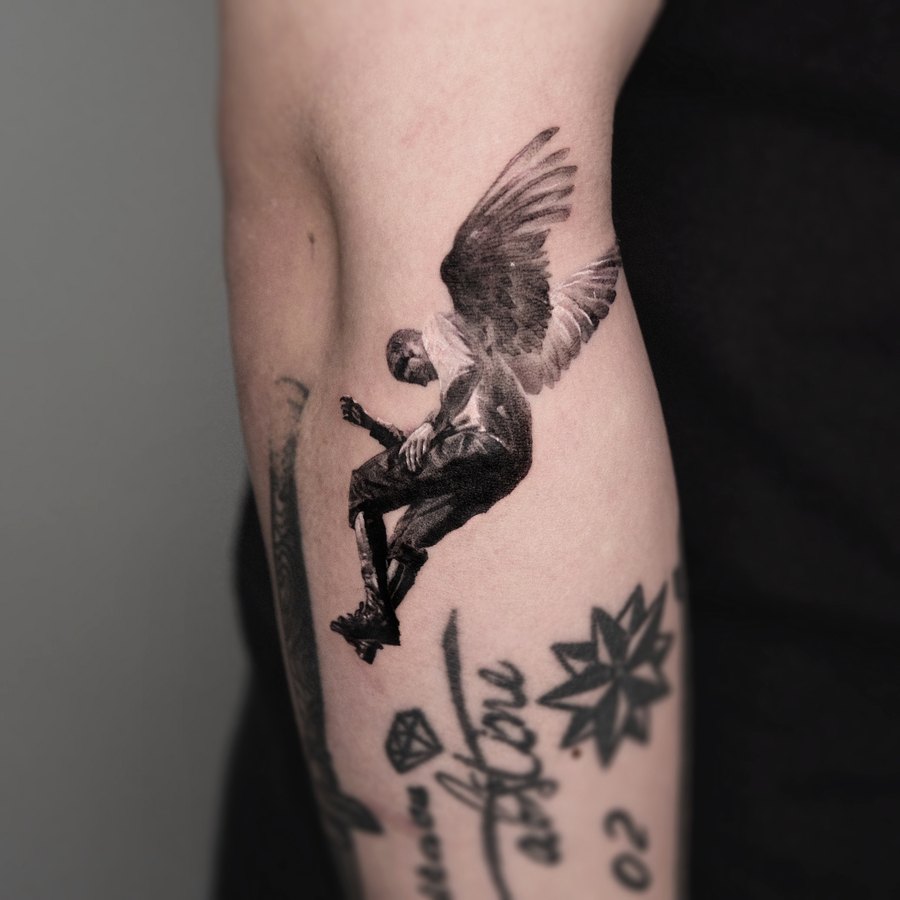 A winged figure tattooed on the arm