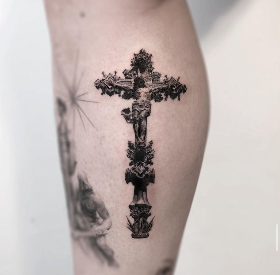 An ornamented cross tattooed on the arm