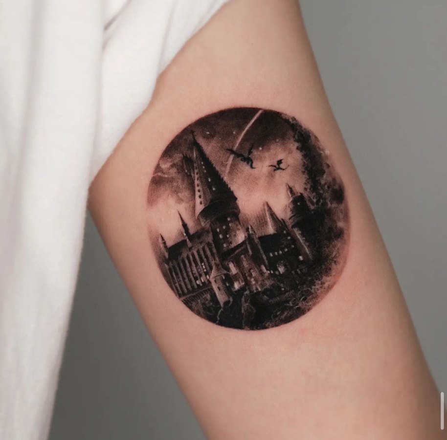 A castle landscape in a circle, tattooed on the arm