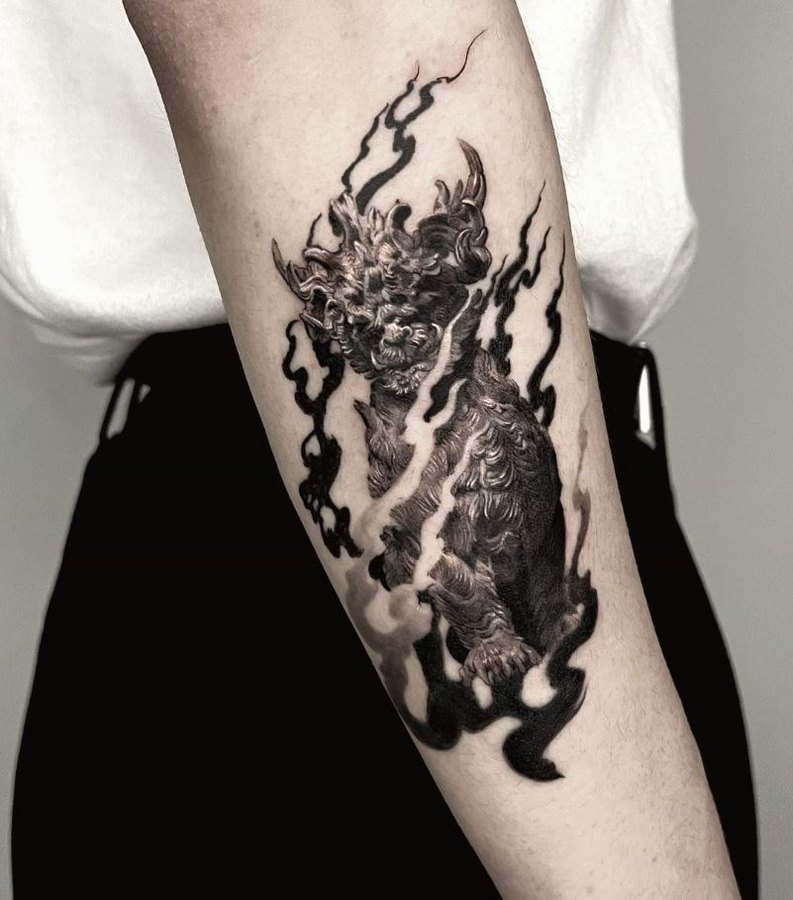 Flames and a dokkaebi tattooed on the arm